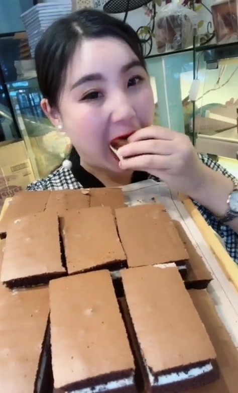 美女在大街上挑战一口吃巧克力砖,夹心的,看着都好吃