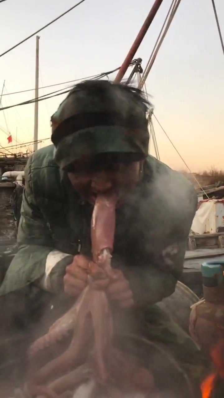 男子在船上吃饭,这章鱼头爆的没毛病,真会吃啊!