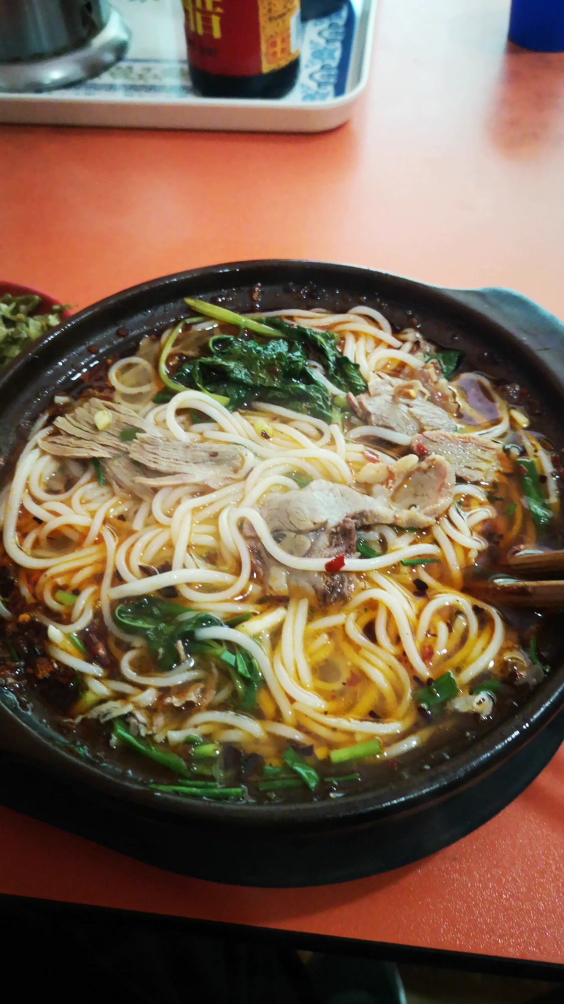 热气腾腾的砂锅羊肉米线,配翠绿的薄荷,再来一碟泡菜,吃得过瘾