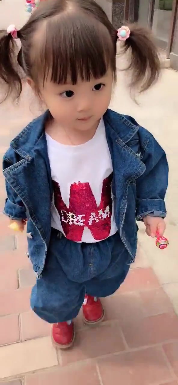 出门遛街的小萝莉,左手拿着棒棒糖,右手握着果冻,走起路萌翻了