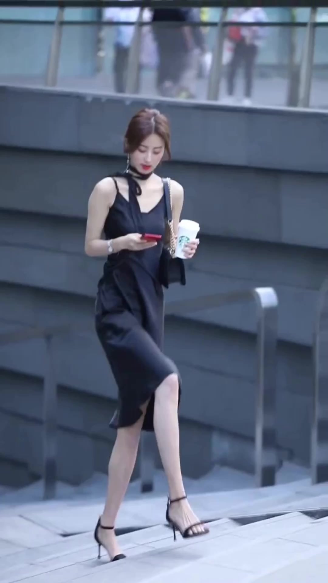 美女手捧奶茶,走路走得很慢