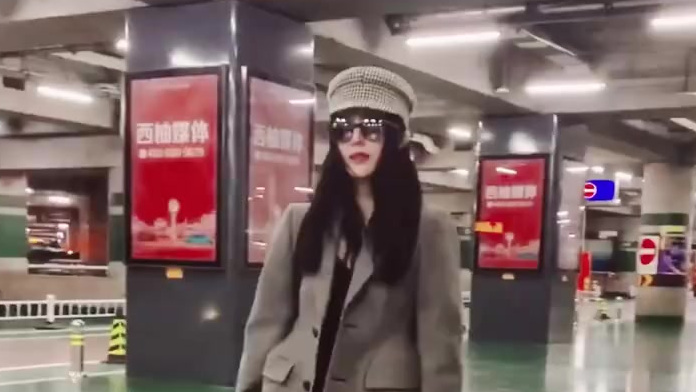 2019年10月9日,身着一袭灰色女士西装与破洞牛仔裤的范冰冰现身北京机场,手持小黄鸭手机