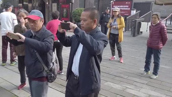 【西安城墙景区下工作人员用银杏叶写书法】昨日,西安城墙中山门景区现场总负责郑女士正在用扫帚