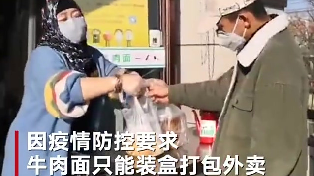 甘肃兰州一家牛肉面复工开业,引来大量食客。因疫情防控要求,牛肉面只能装盒打包外卖。顾客们在