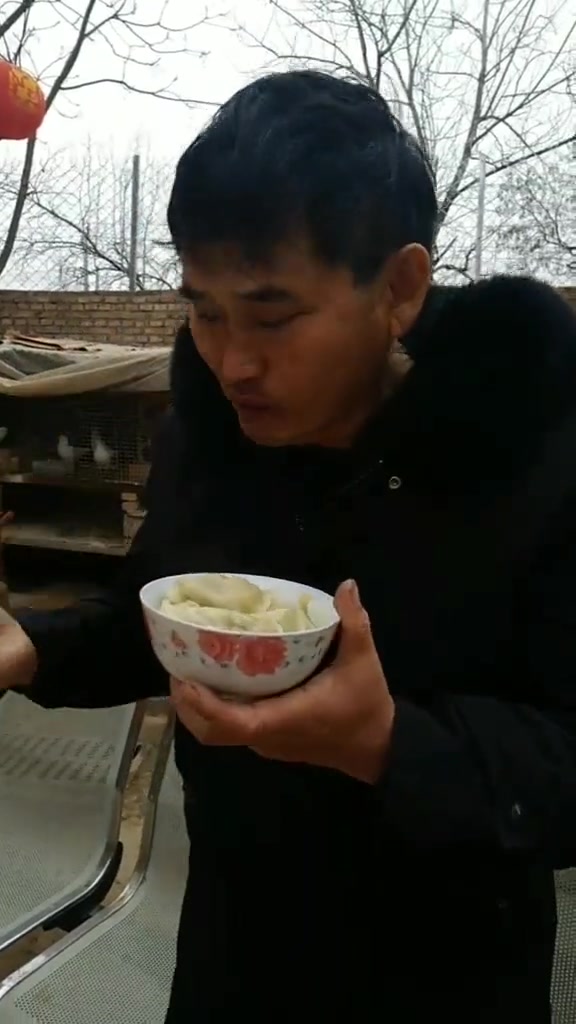 大衣哥端着碗在院子里吃饺子,一边吃一边赞美野菜饺子好吃