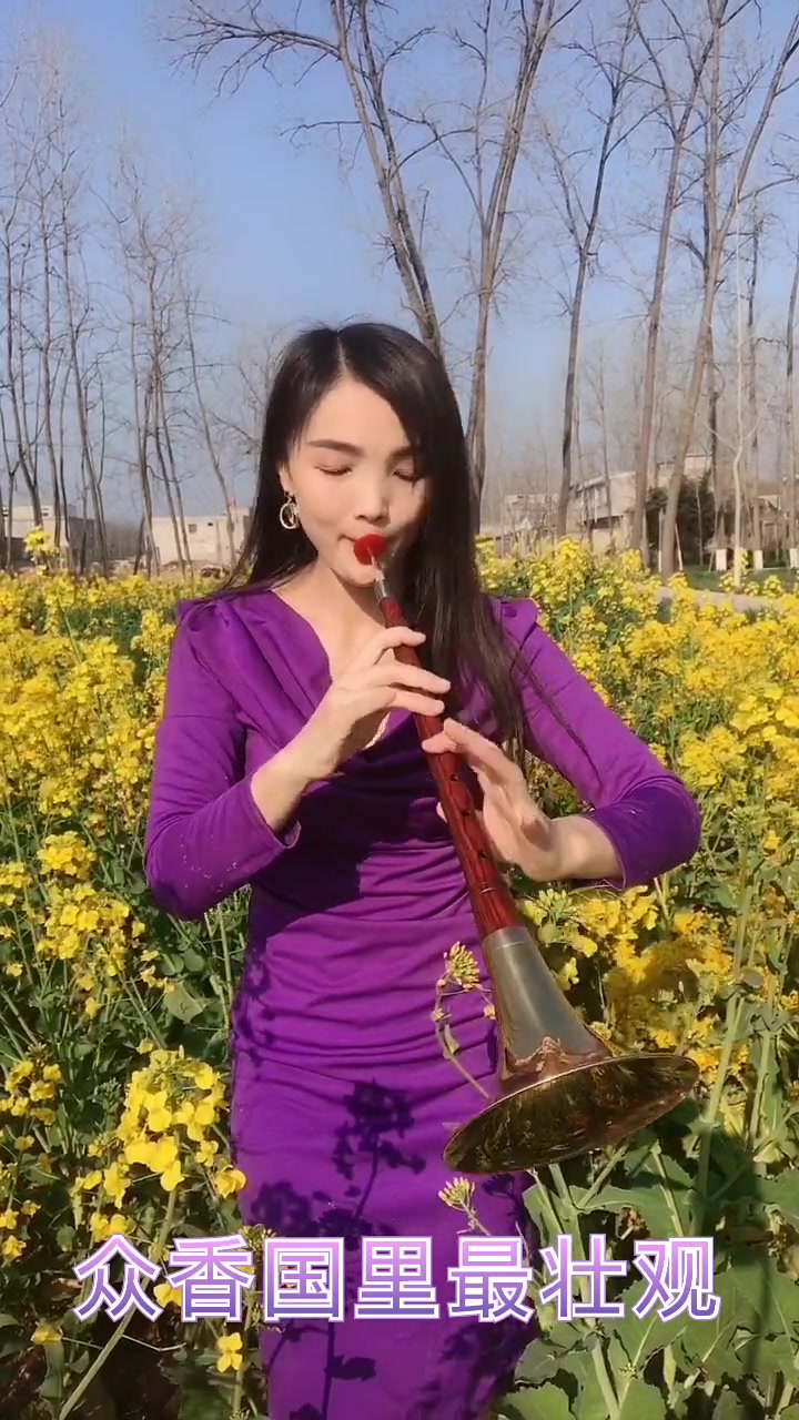 美女站在油菜花中吹奏唢呐牡丹之歌