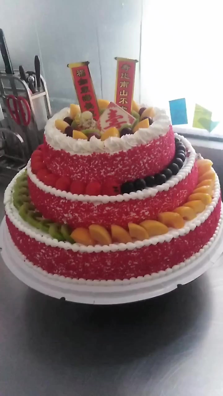 今天的生日蛋糕是红色的,而且还有三层,看起来很大