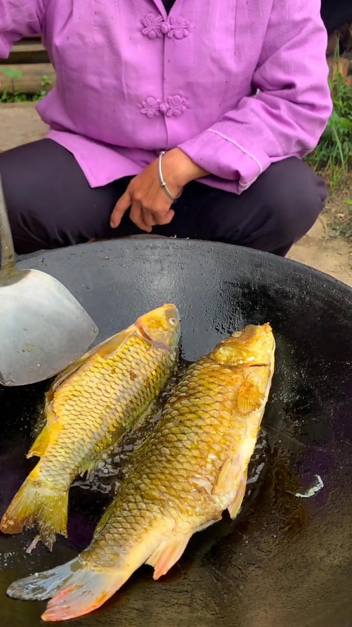 农村大妈煎稻花鱼,看着好像鱼鳞都没刮,应该是挺有营养的