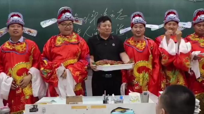 【校领导穿状元服给高考生送鲤鱼粽子 :寓意鲤鱼跃龙门 状元定高“粽”】5月31日,河南郑州