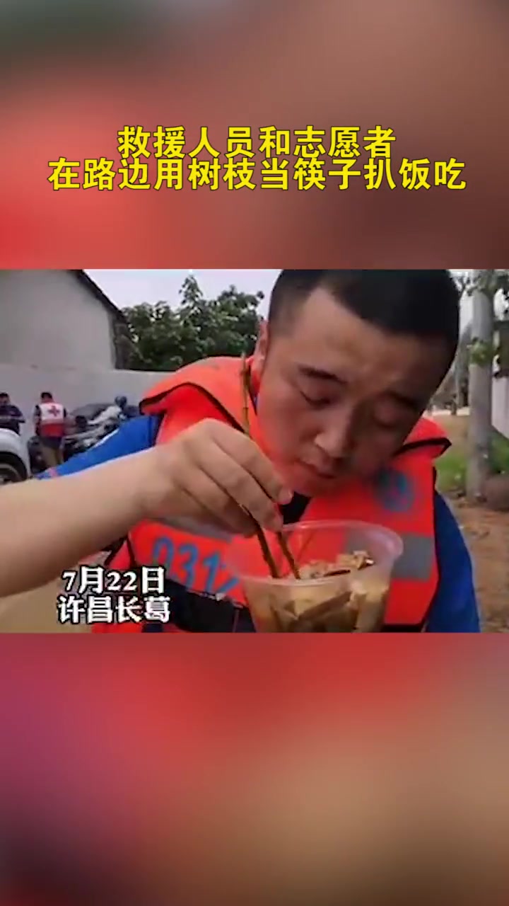 因筷子不够用 河南许昌 一救援人员在路边用树枝当筷子扒饭吃