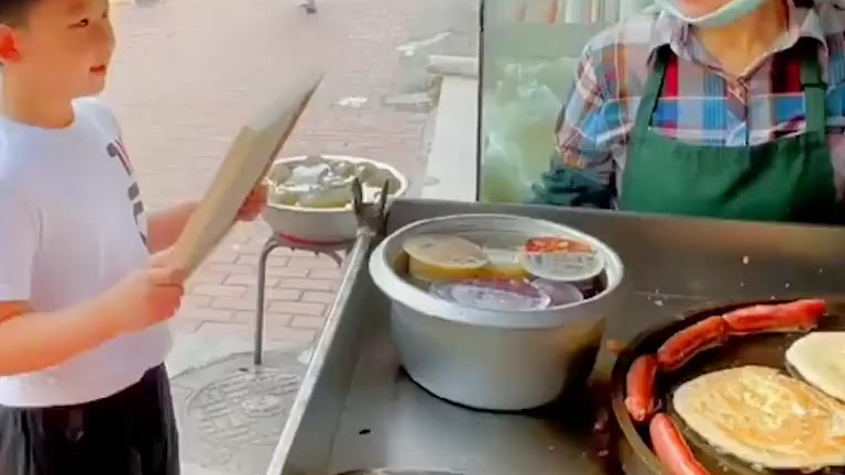 【8岁小男孩绘画像送早餐摊夫妻:觉得他们很辛苦[爱你]】8月8日,山东青岛。八岁男孩用一天