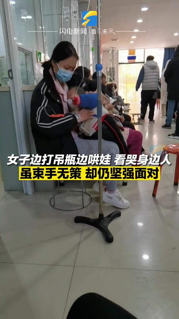 女子边打吊瓶边哄娃,看哭身边人,虽束手无策却仍坚强面对。女本柔弱为母则刚