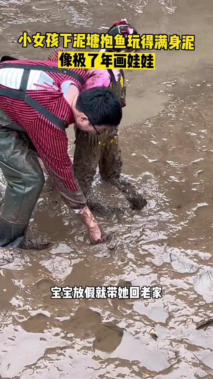 1月4日,四川内江,小女孩下泥塘抱鱼玩得满身泥,像极了年画娃娃 年画娃娃 抓鱼 农村生活 