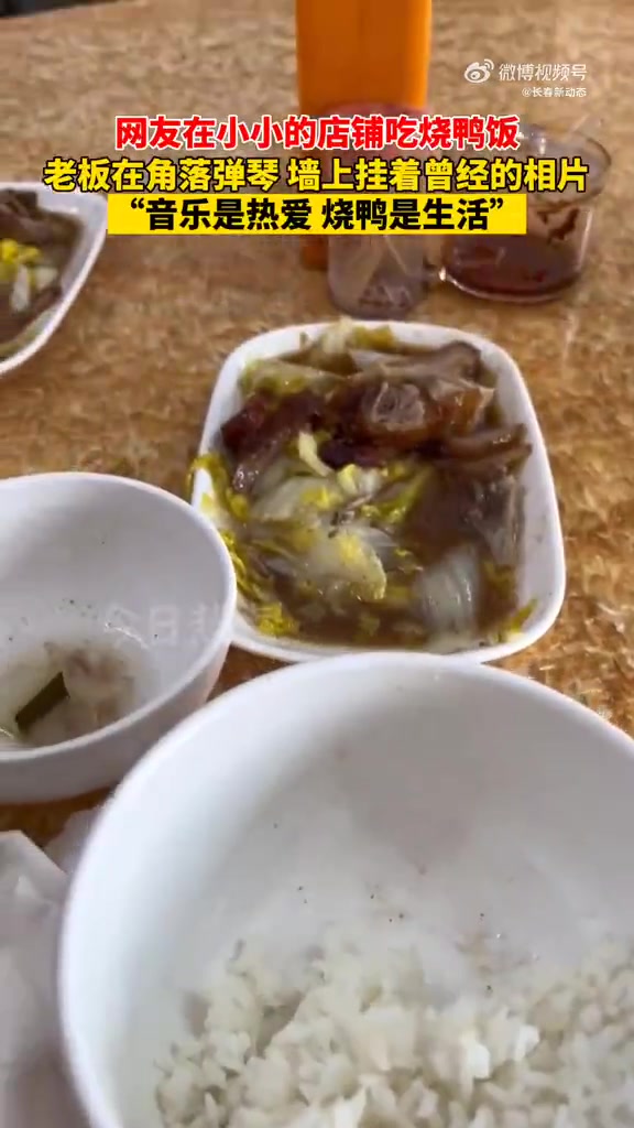广东,网友在小小的店铺吃烧鸭饭,老板在角落弹琴,墙上挂着曾经的相片“音乐是热爱 烤鸭是生活
