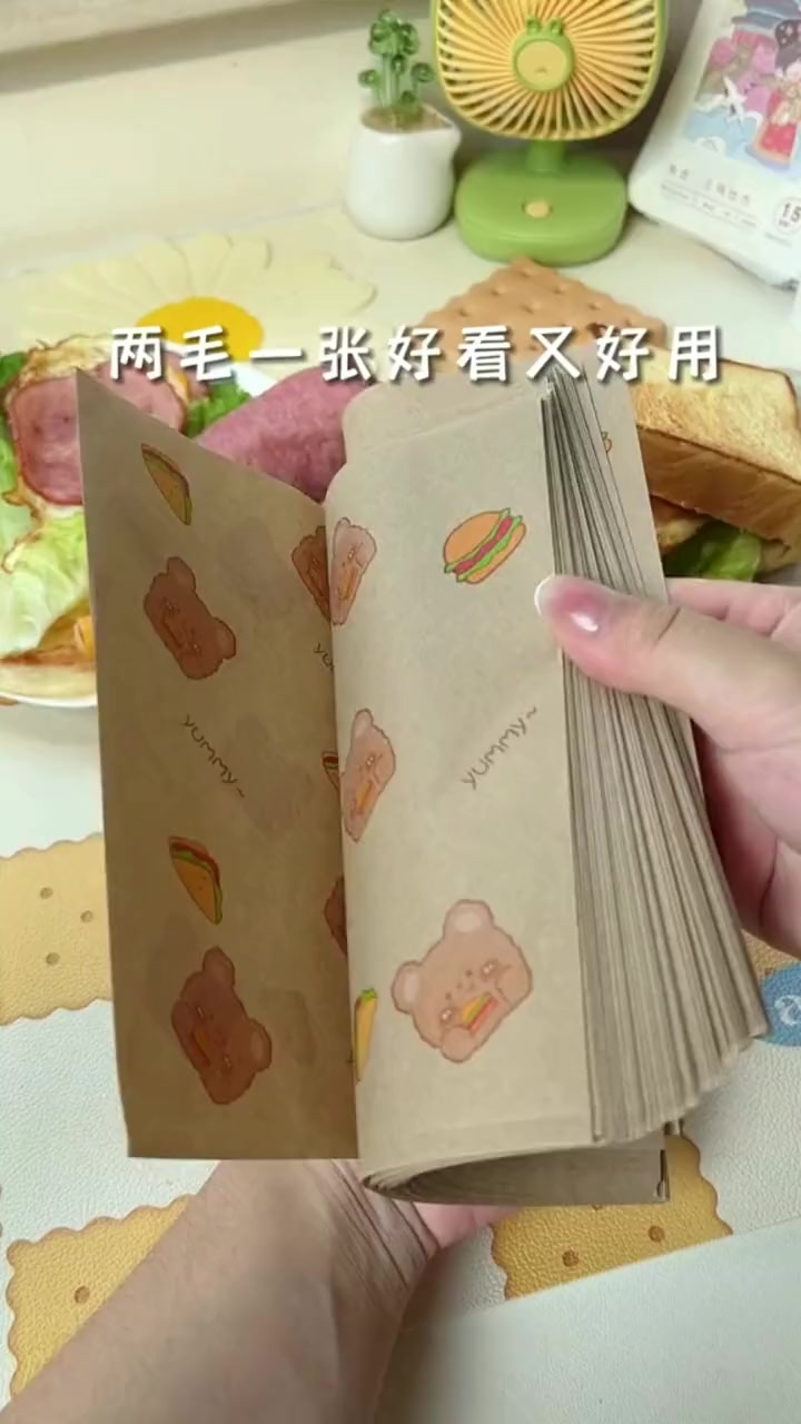 做好的手抓饼或者三明治,用这个纸,垫着就可以直接拿着吃了,还可以路上带着吃。三明治包装纸 