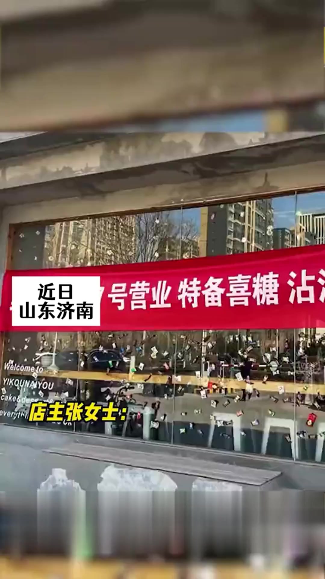 甜品店主结婚店休息,在玻璃墙上贴横幅和喜糖,路过行人纷纷拍照沾喜气