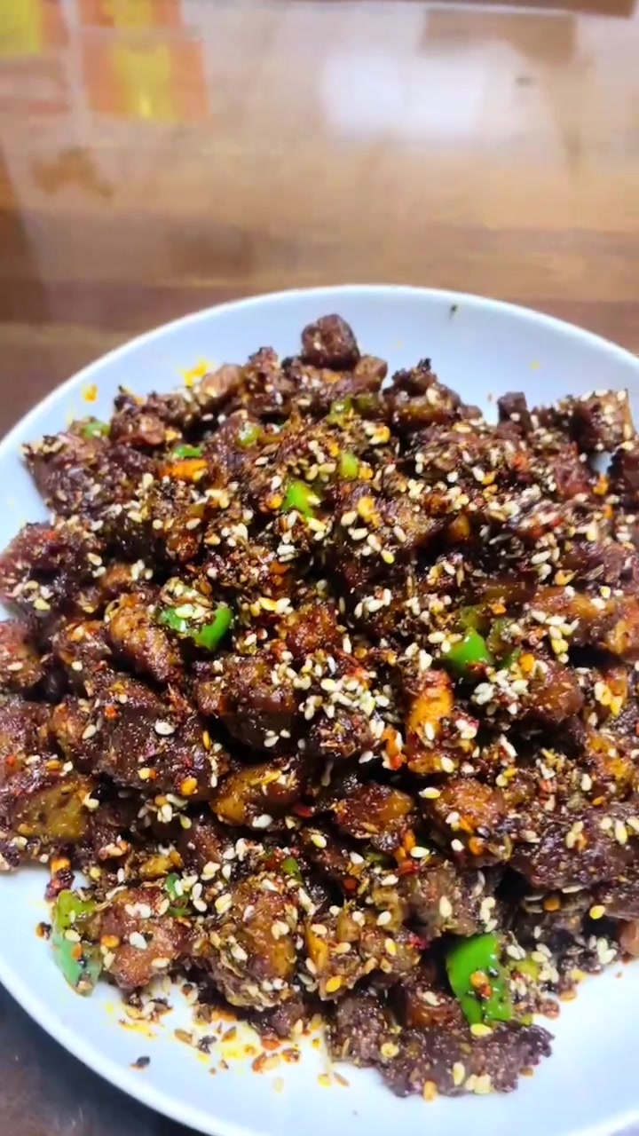 烟火人间,最抚人心。几块鲜嫩的肉切成小块,在锅中滋滋作响。撒上灵魂孜然,那浓郁的香气瞬间弥