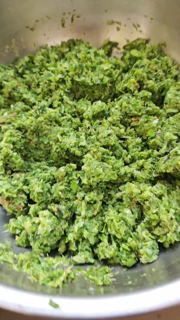 第二次试验槐花煎饼，将洗干净的槐挤水放入料理机，将韭菜大葱切小段放入料理机打碎，放盐十三香