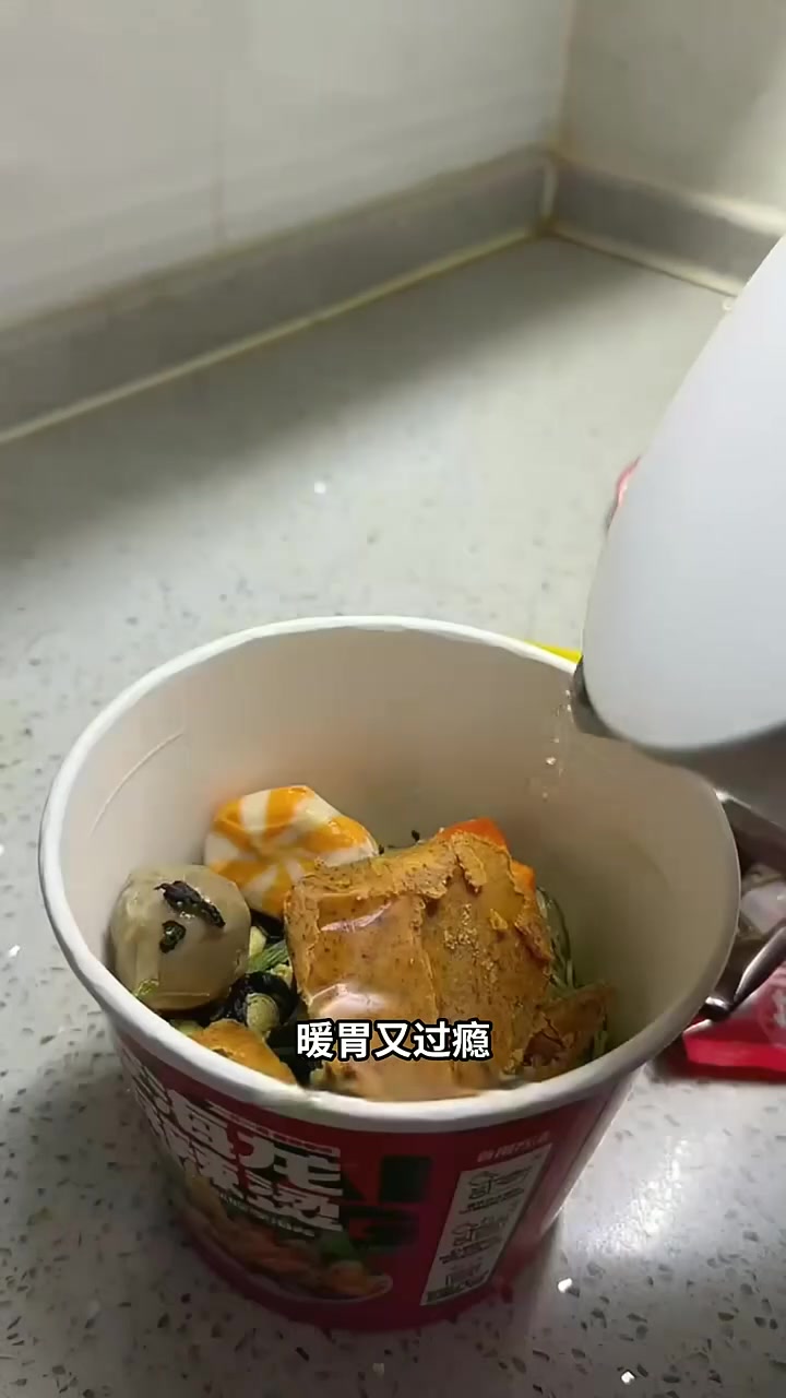 老人晨练结束,在路边长椅上休息,拿出李海龙桶装麻辣烫,用保温杯热水冲泡,吃着热乎的麻辣烫,