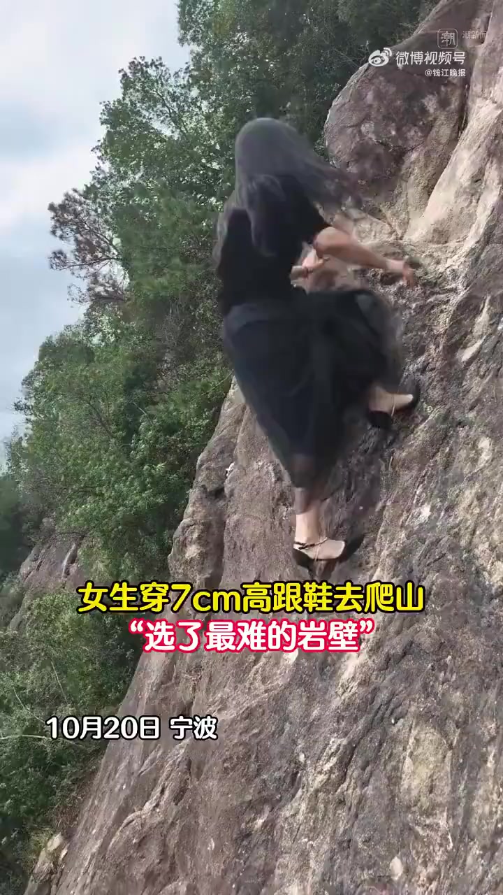 「穿高跟鞋爬楼是对膝盖的酷刑」近日，浙江宁波一名女子身穿纱裙和7厘米高跟鞋在岩壁爬山，如履