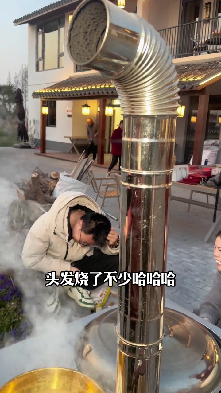 我们在小院里做地锅鸡，小翟和我抢烧火的工作，然后把自己的头发烧了。我笑他过年要自己烫头，我