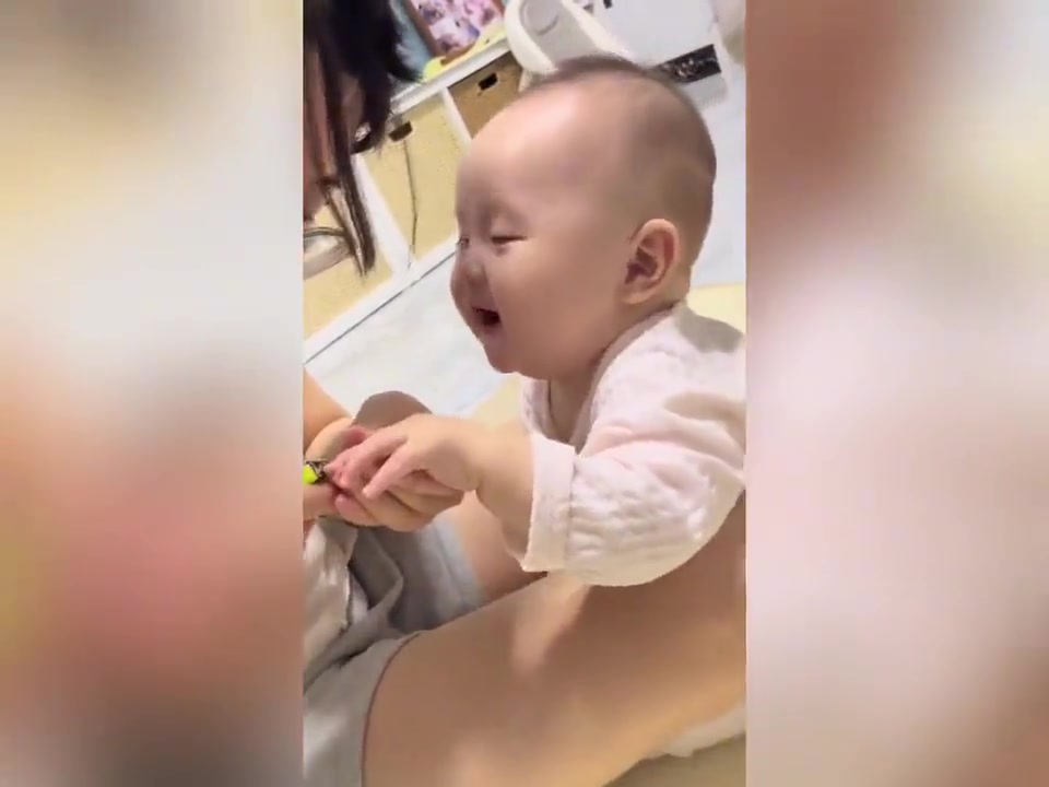 妈妈给宝宝剪指甲，宝宝时不时偷看妈妈，奶呼呼的太可爱了