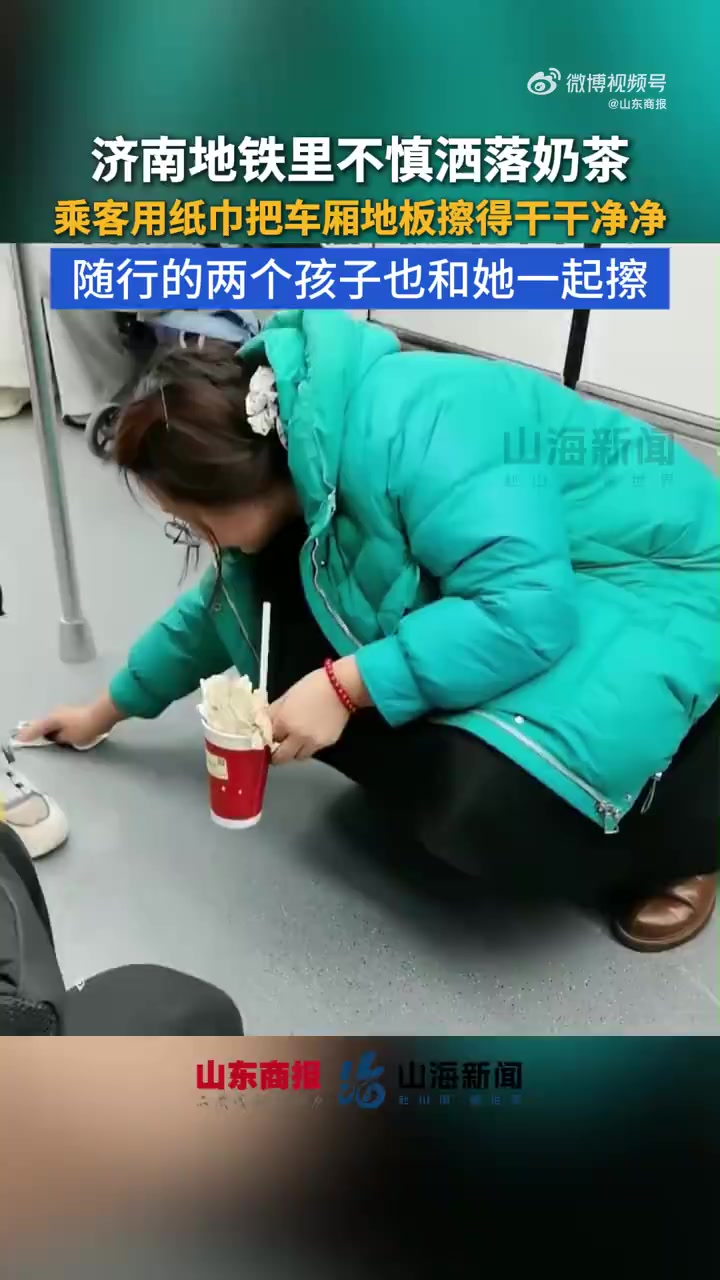 近日,济南。地铁4号线上,一名女子乘车时不慎将奶茶洒在车厢地面,她立刻蹲下清理。随行的两位