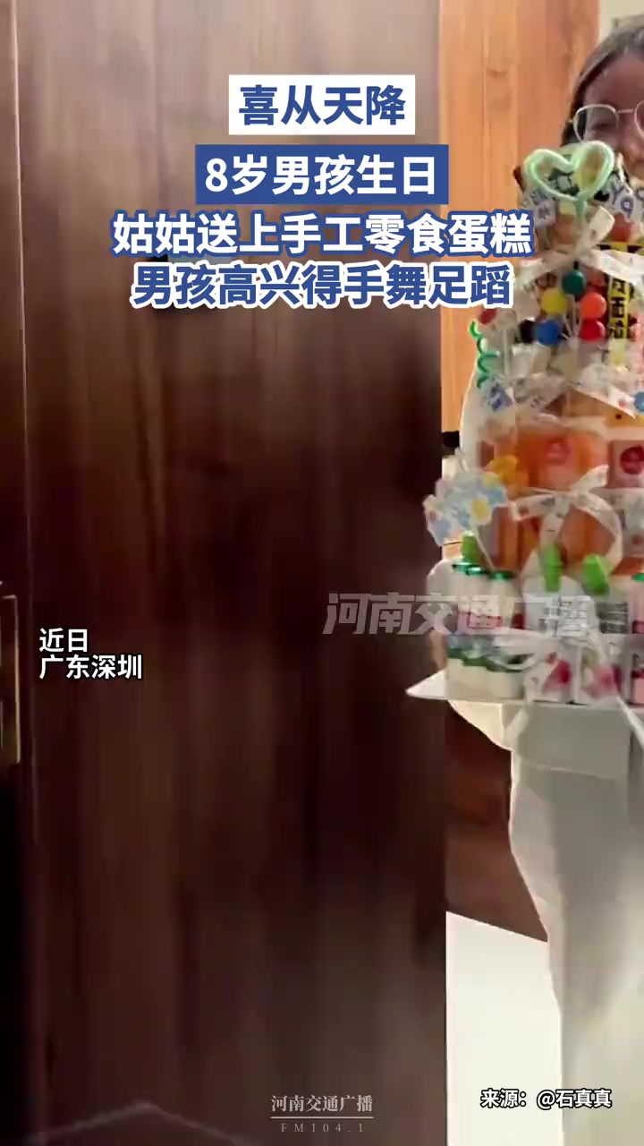 喜从天降。8 岁男孩生日,姑姑送上手工零食蛋糕,男孩高兴得手舞足蹈。@石真真