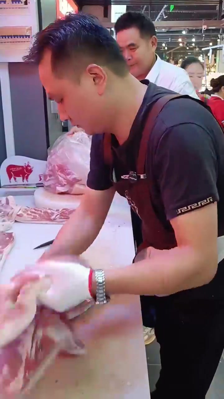 肉店工作人员分割猪肉装袋过程实录