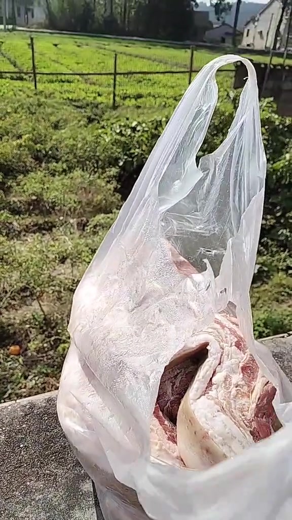 农村户外摆放新鲜猪肉及周边田园