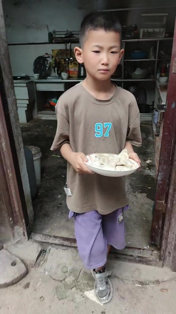 可爱萌娃手托饺子盘从厨房走到屋外