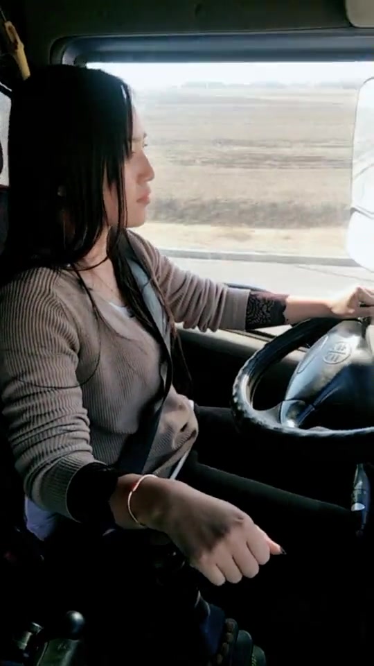 漂亮的货车女司机一个手就把方向盘扶的稳稳的