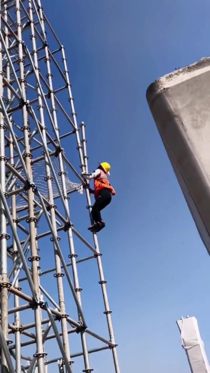 眼前这一幕值得我们敬佩,女子架子工在百米高空攀爬作业