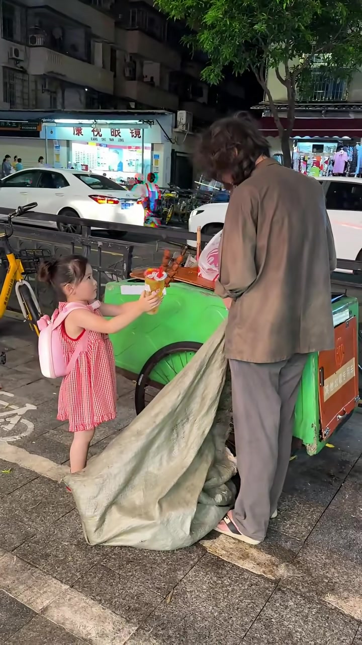 女儿看到街头流浪者正在翻垃圾桶找吃的,用自己的零花钱买了烤肠和