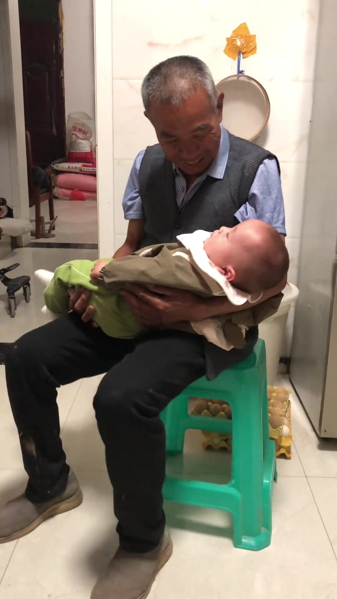 宝宝在太爷爷怀里睡着了,老人怕熟睡的重孙醒来,抱着宝宝轻轻的摇晃